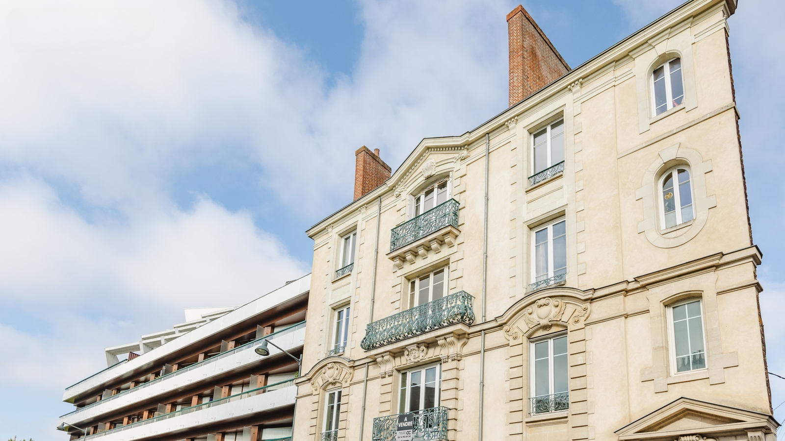La façade de l'immeuble et ses balcons en fer forgé