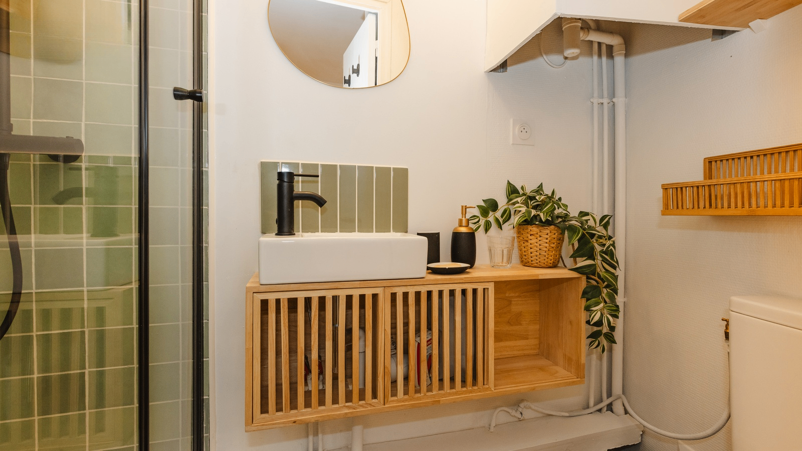 La salle de bain avec sa vasque et son meuble en bois